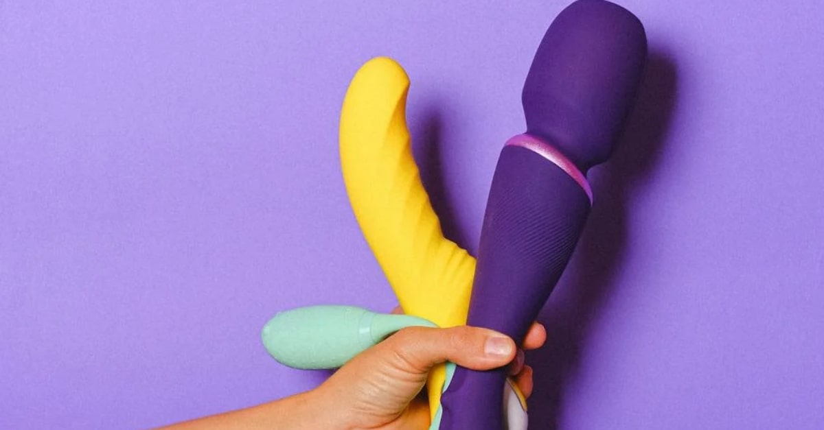 Someone holding up 3 different sex toys